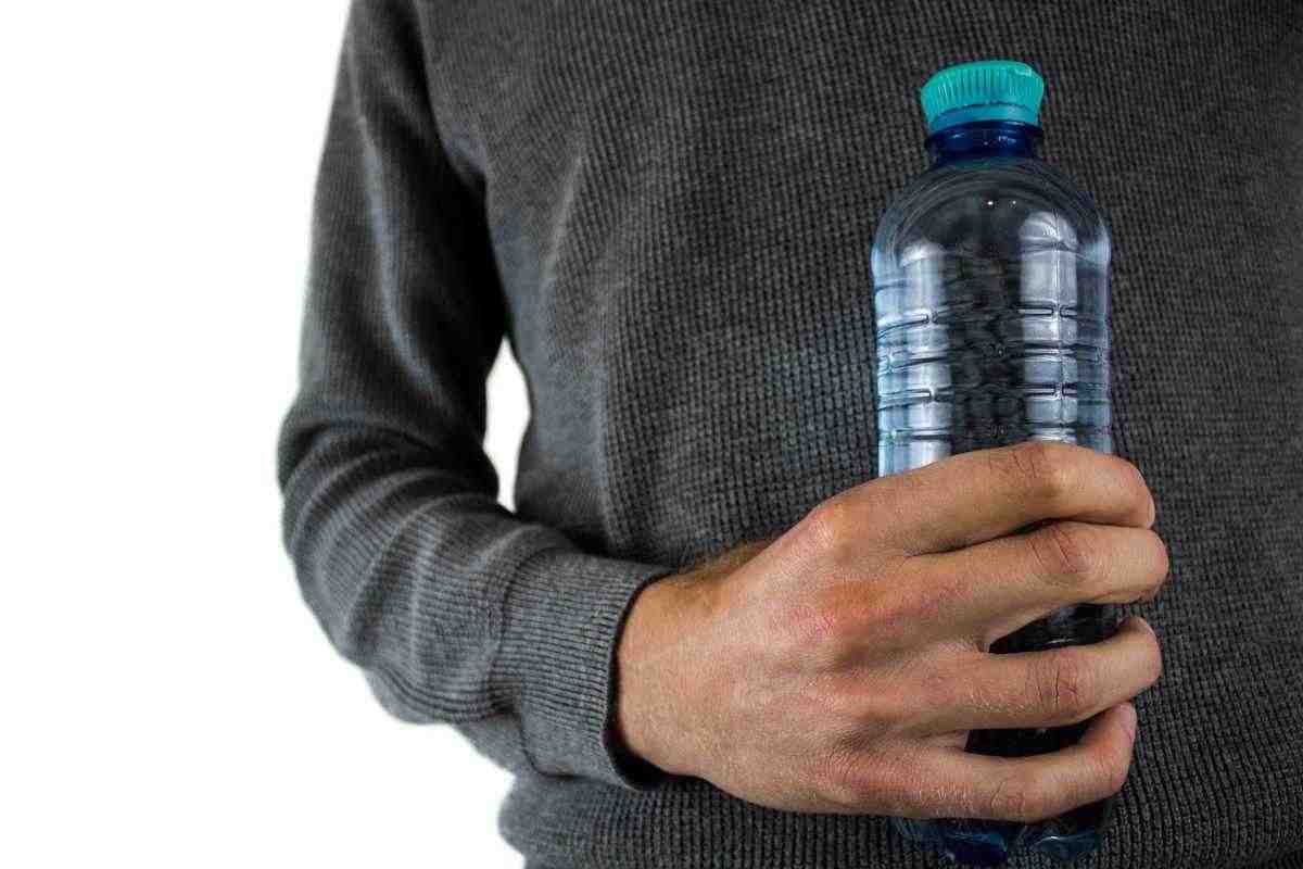 Uomo che tiene una bottiglia d'acqua