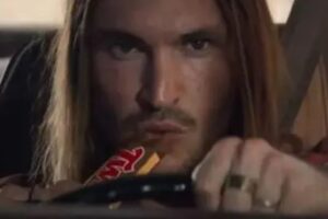 Un frame della pubblicità del Twix con uomo che mangia snack mentre guida