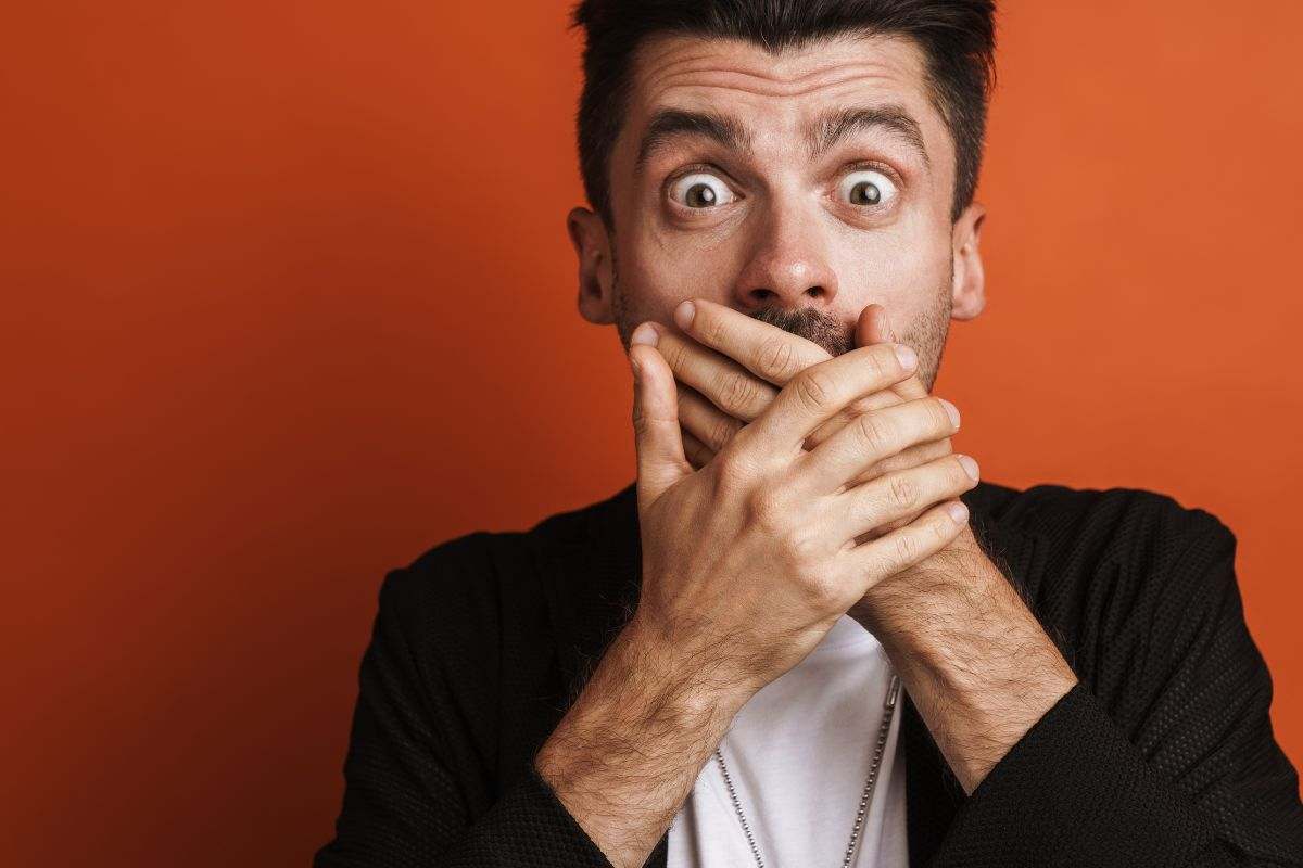 Uomo si tappa la bocca per non parlare