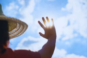 donna copre il sole con una mano