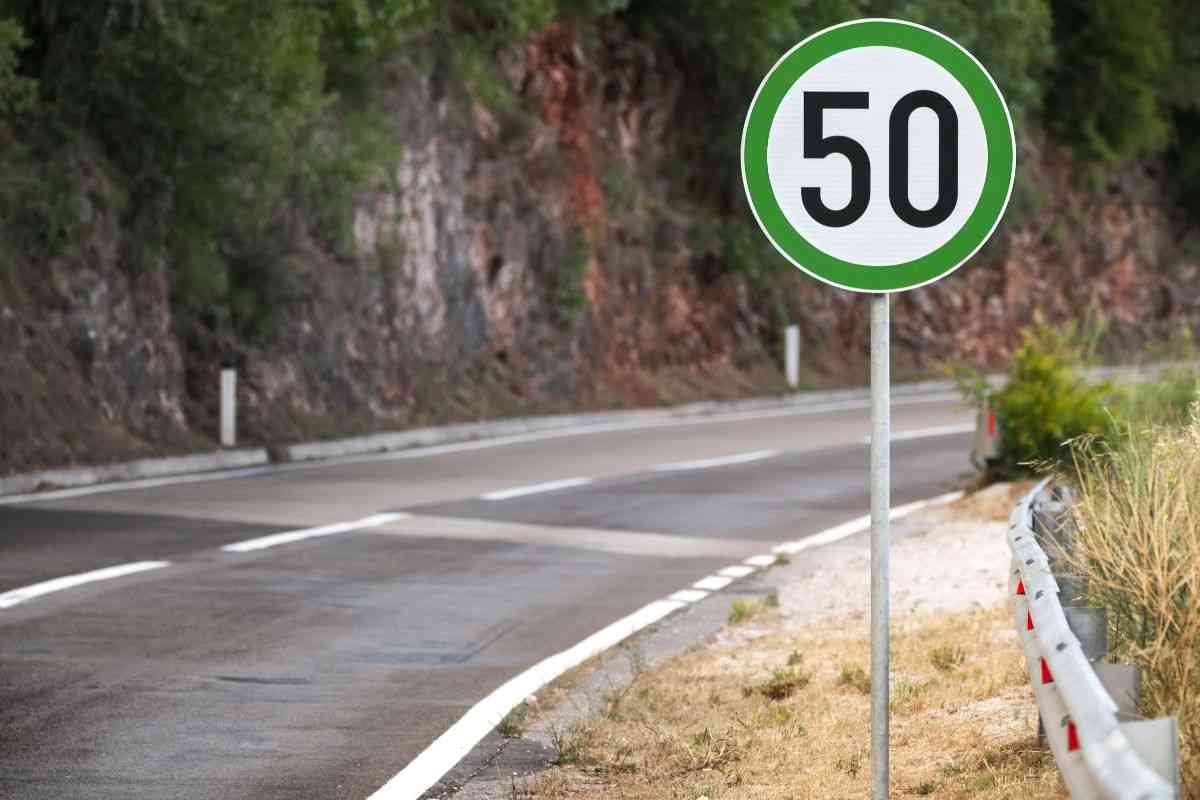 cartello stradale con bordo verde su strada di montagna
