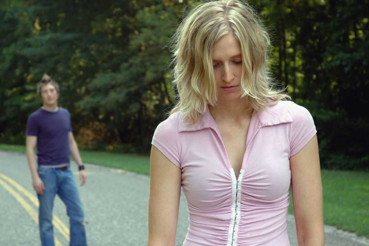 donna triste si allontana da un uomo