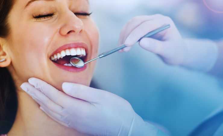 dentista che guarda i denti a una ragazza