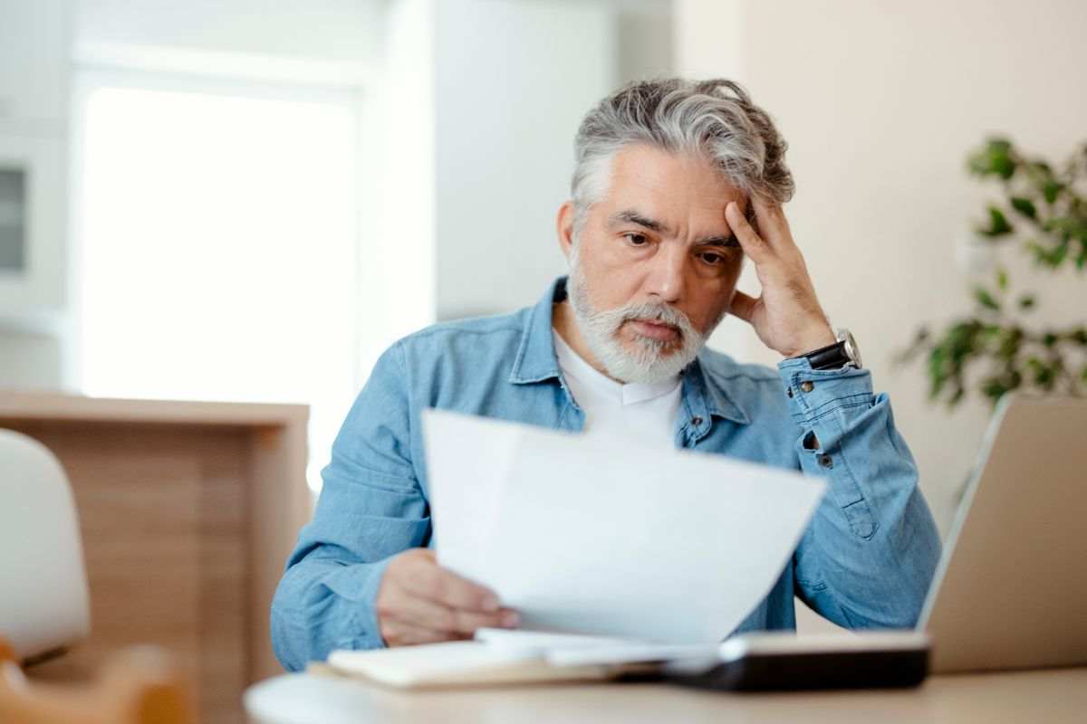 uomo preoccupato che legge un documento