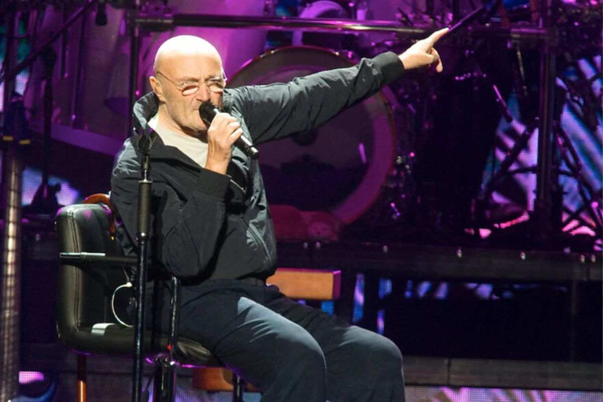 Phil Collins canta seduto sulla sedia