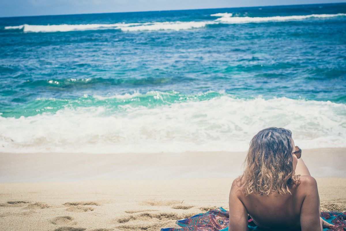 Ragazza prende il solo in spiaggia