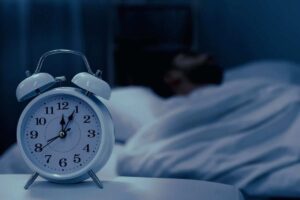 uomo a letto e sveglia