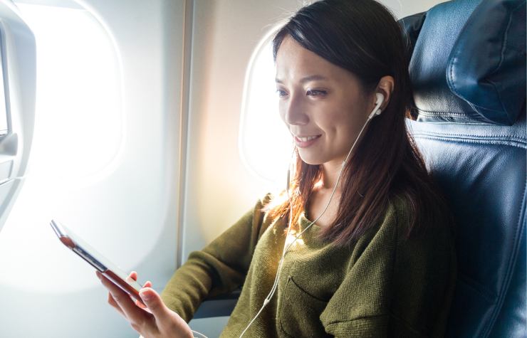 donna con smartphone in mano in aereo 
