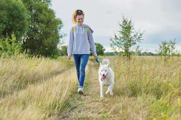 Donna con cane in spazio verde